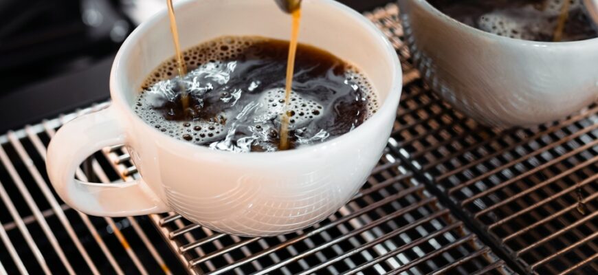 Close-up,Of,Americano,Pouring,From,The,Coffee,Machine,Into,A